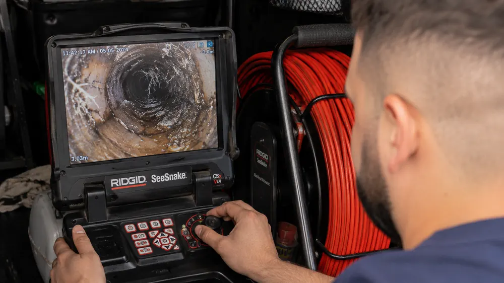 Technician reviewing CCTV footage of a drain blockage